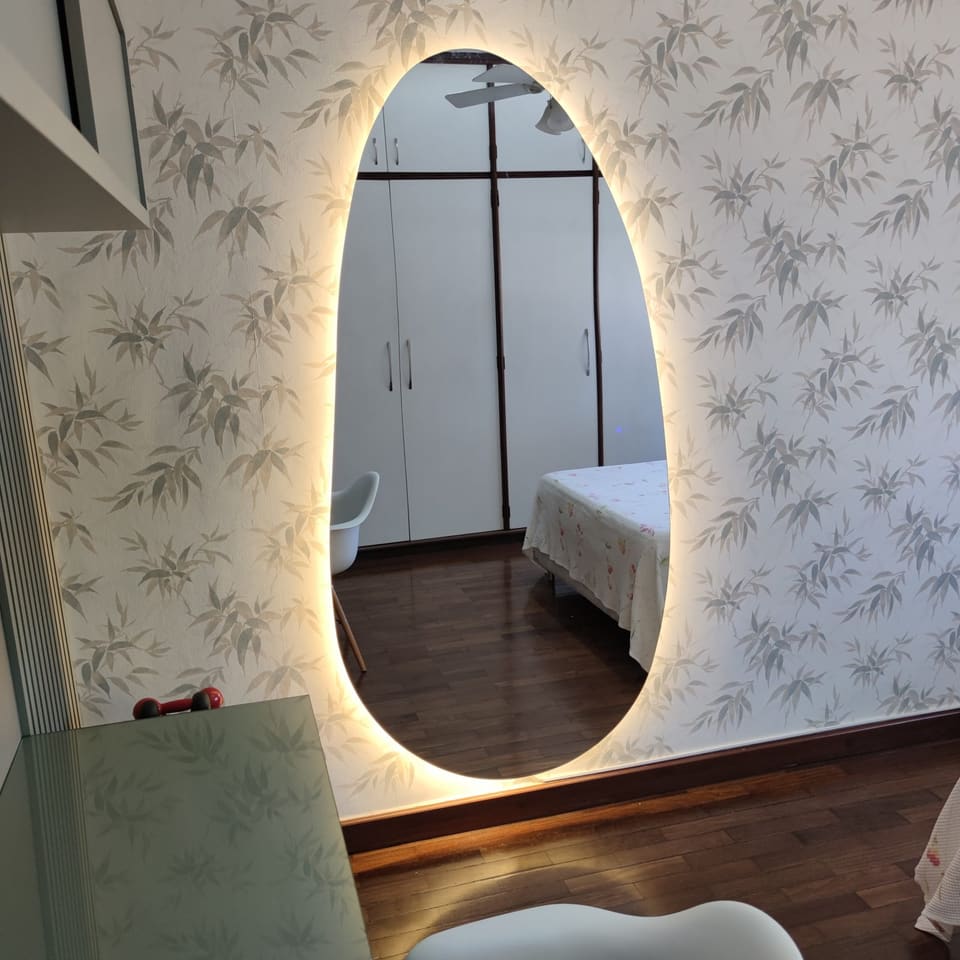 Espelho orgânico com LED aceso em banheiro de madeira